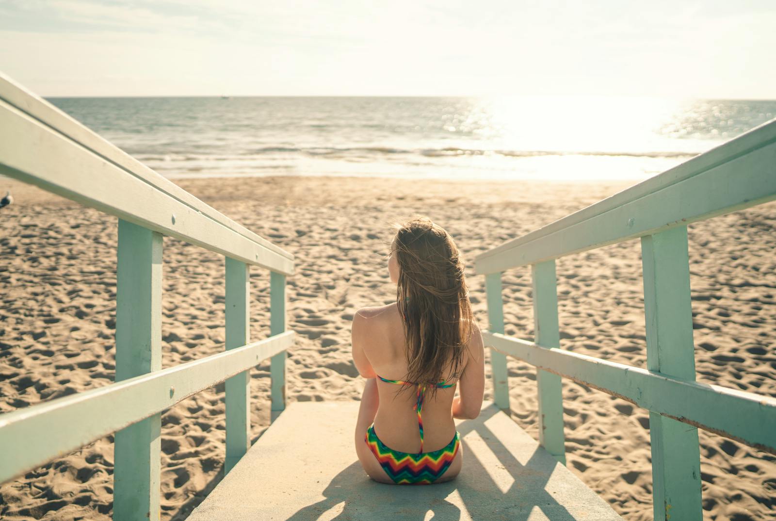 Woman in Bikini Sitting on a Beach 
