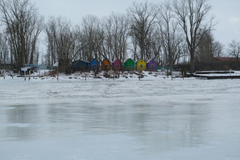 Colorful sheds sit in a snowy landscape.
