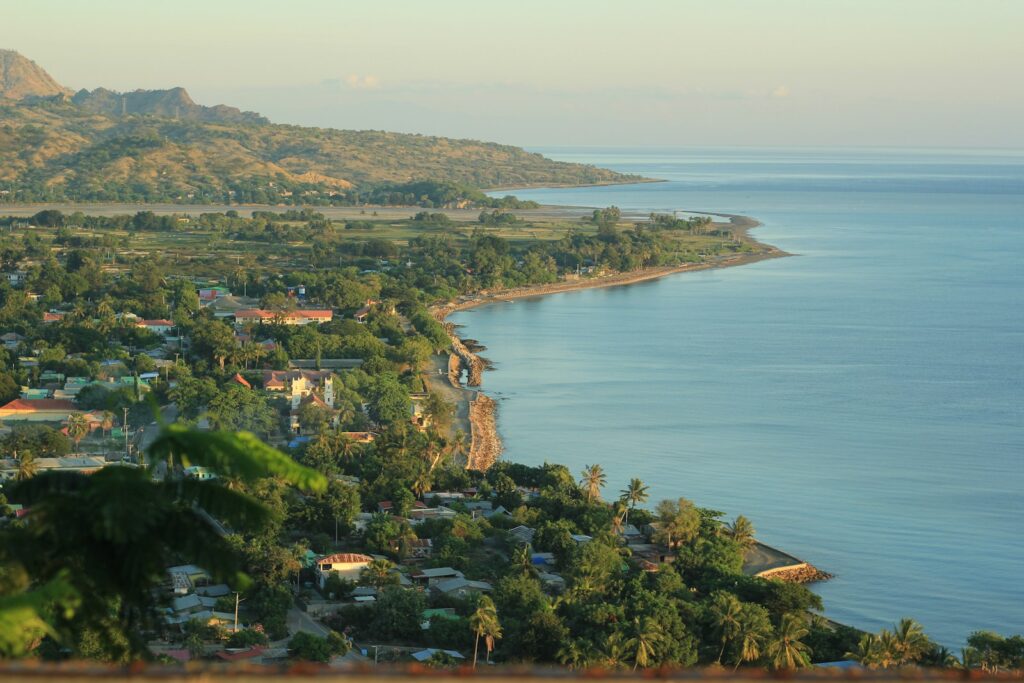 a view of a town and the ocean from a hill