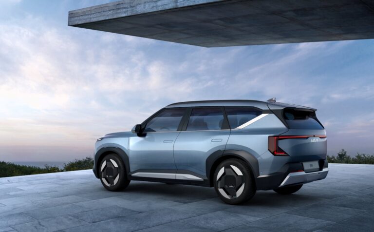 Sleek electric SUV parked on a modern driveway with a scenic backdrop.