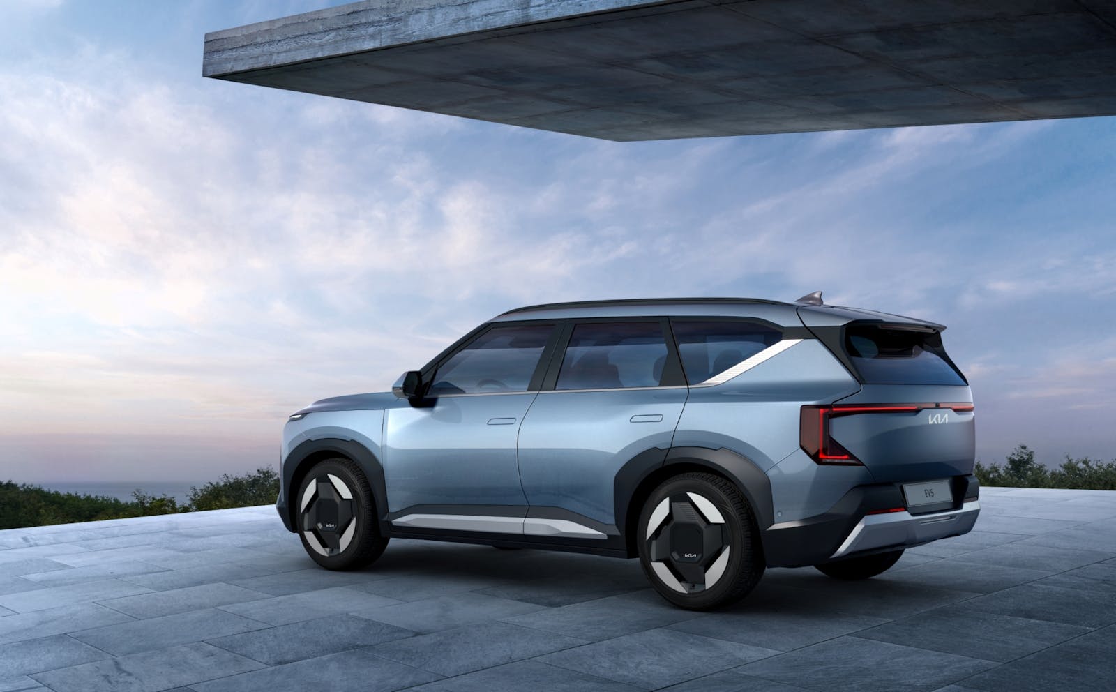 Sleek electric SUV parked on a modern driveway with a scenic backdrop.