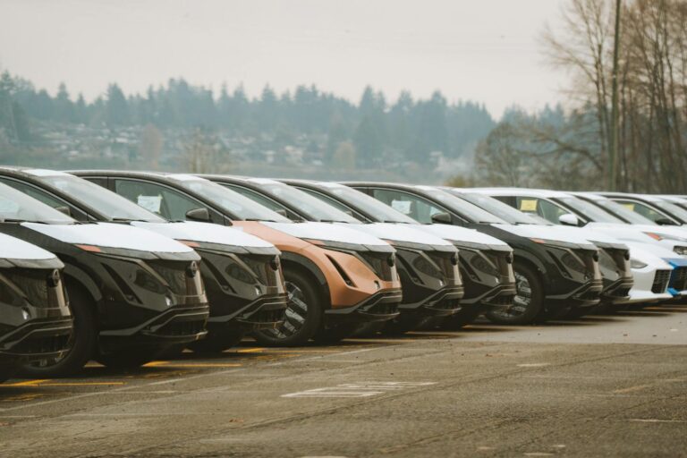 Rows of sleek electric cars parked outdoors, showcasing automotive design and innovation.