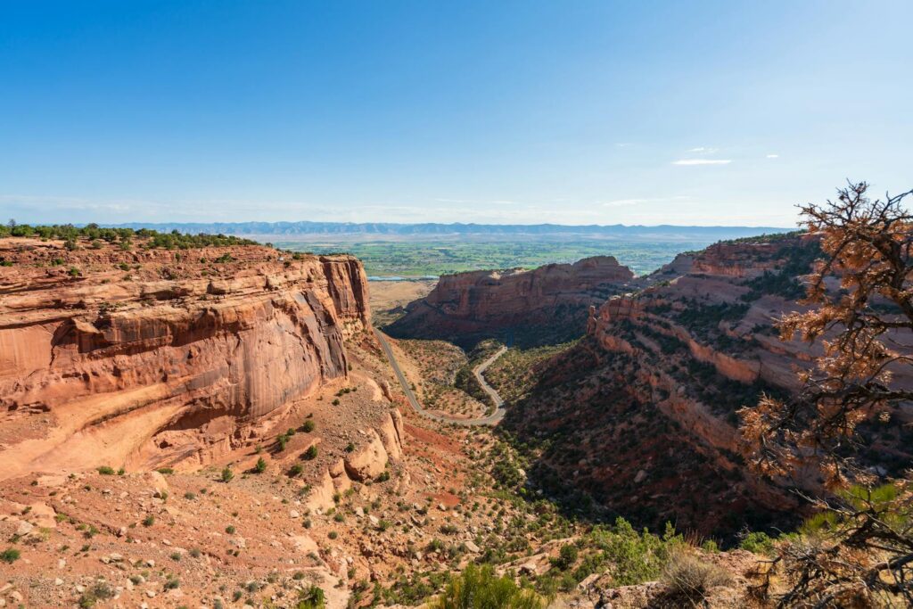 Stunning canyon view in Colorado National Monument with vibrant red rock formations under a clear blue sky.
