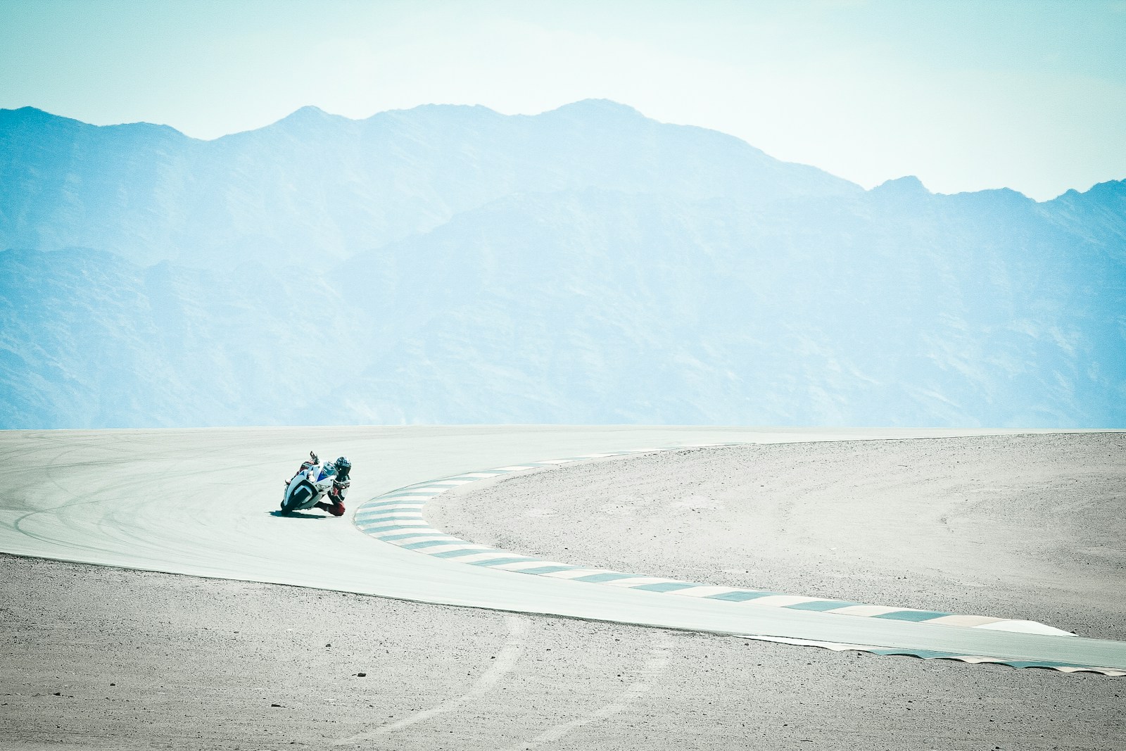 person in black jacket sitting on gray sand during daytime