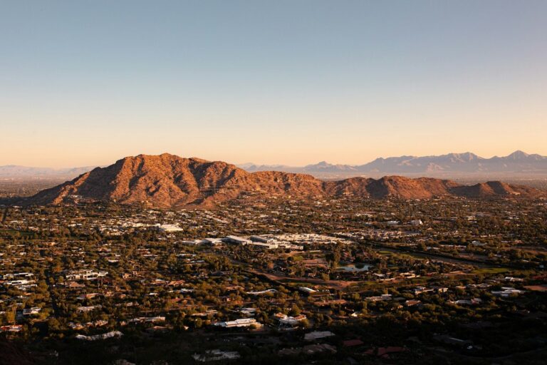 an aerial view of a city with mountains in the background