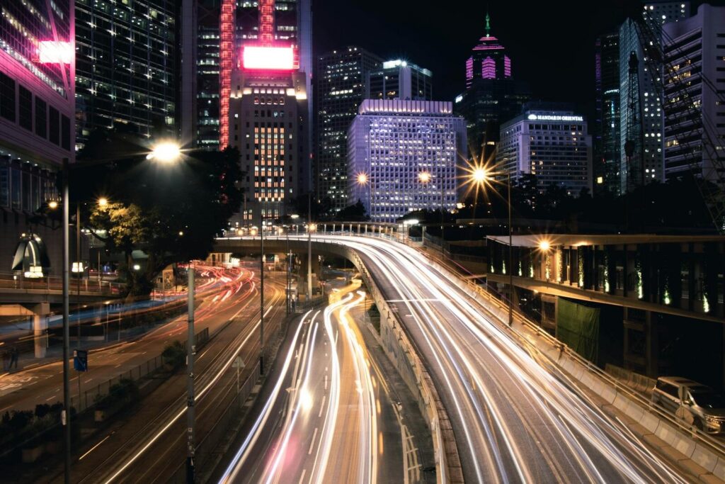 Dynamic night cityscape of Hong Kong with vibrant light trails and skyscrapers.