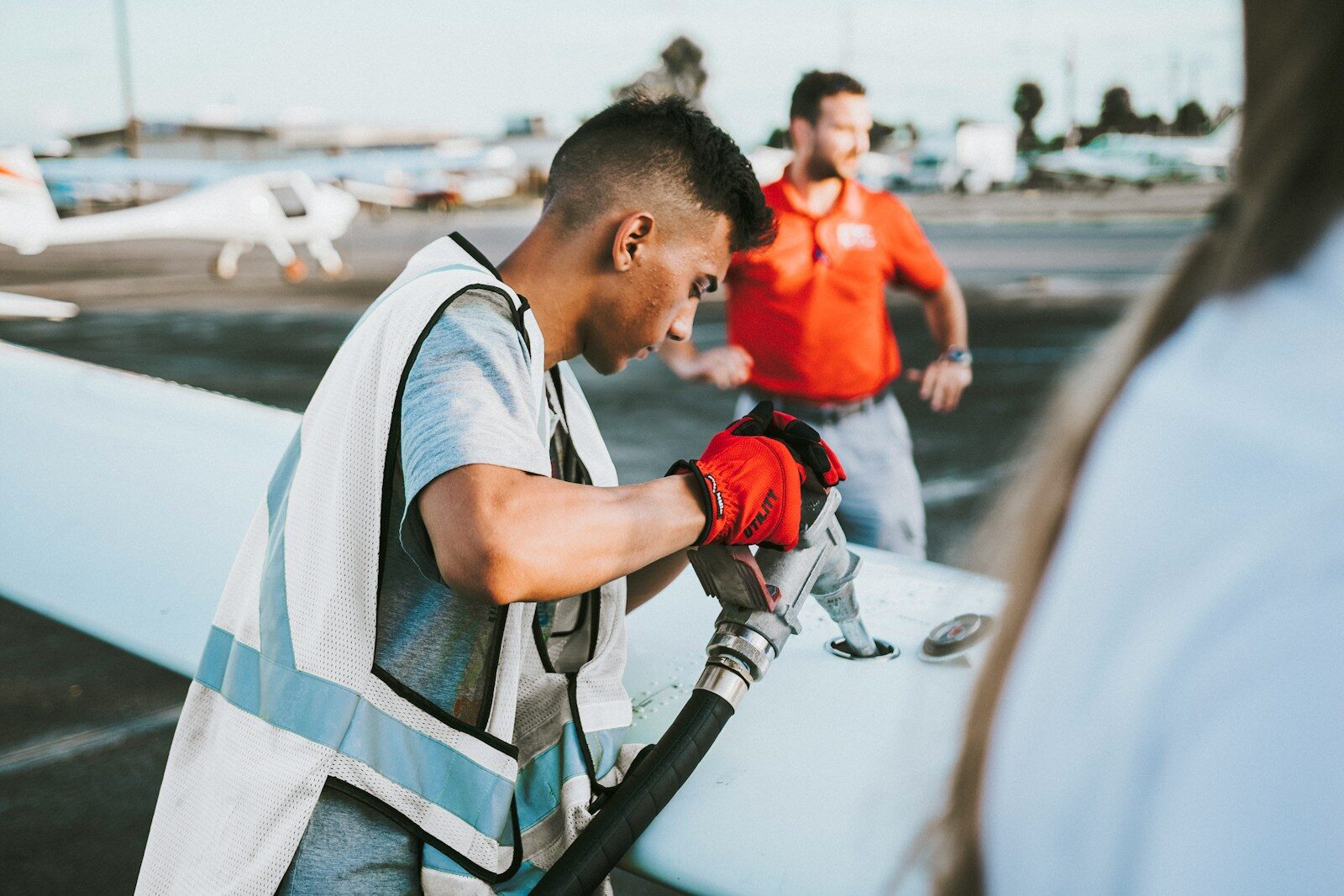 man fueling plane near man
