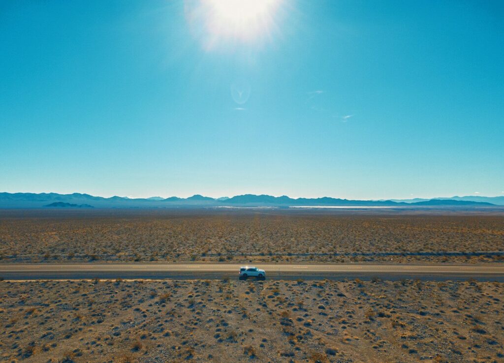 a car driving down a road in the middle of the desert