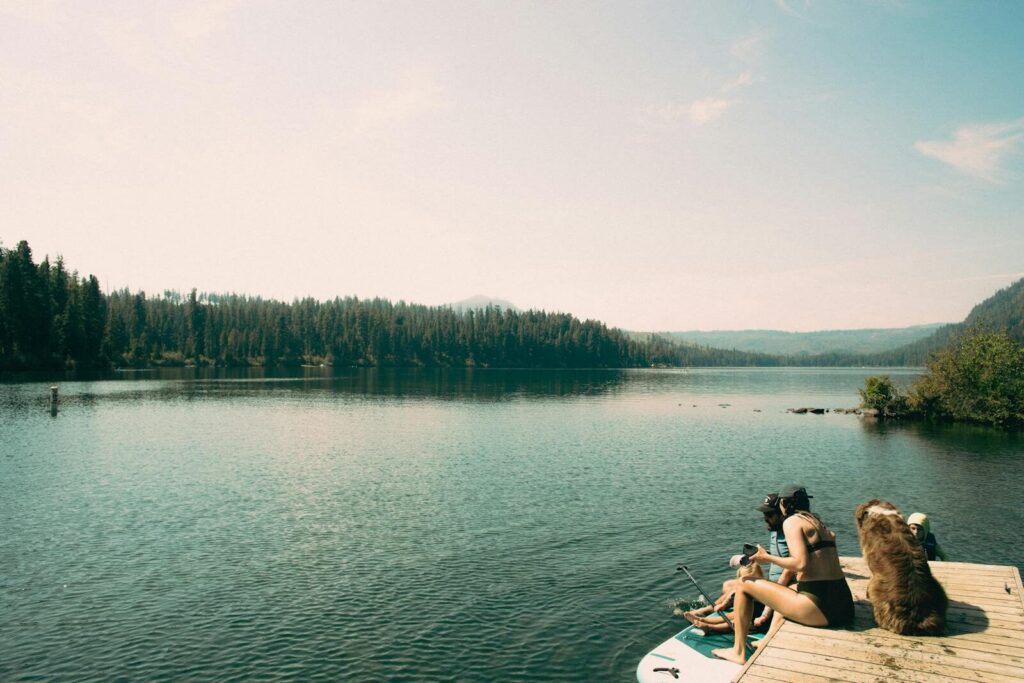 Peaceful moment by a stunning lake in Bend, Oregon, with friends and a dog enjoying nature.