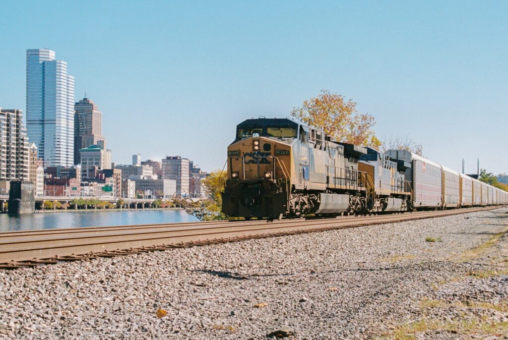 A train traveling down train tracks next to a river