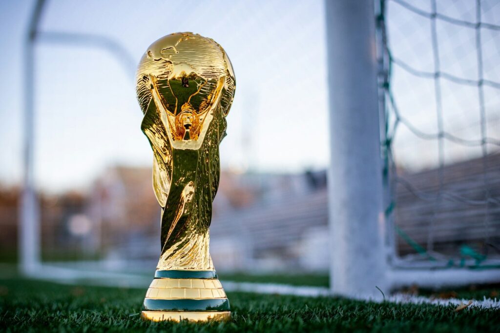 a golden soccer trophy sitting on top of a field