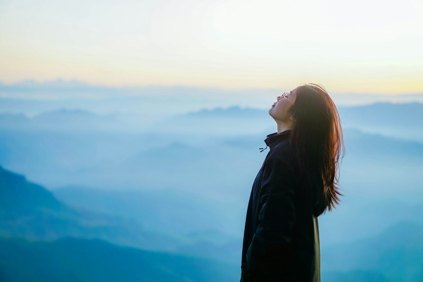 a person with a backpack looking out over a valley
