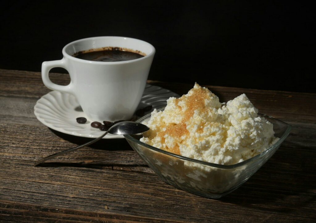 A cup of coffee and a bowl of cottage cheese