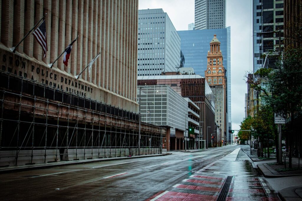A rainy day view of Houston's downtown architecture featuring modern and historical buildings, empty street.