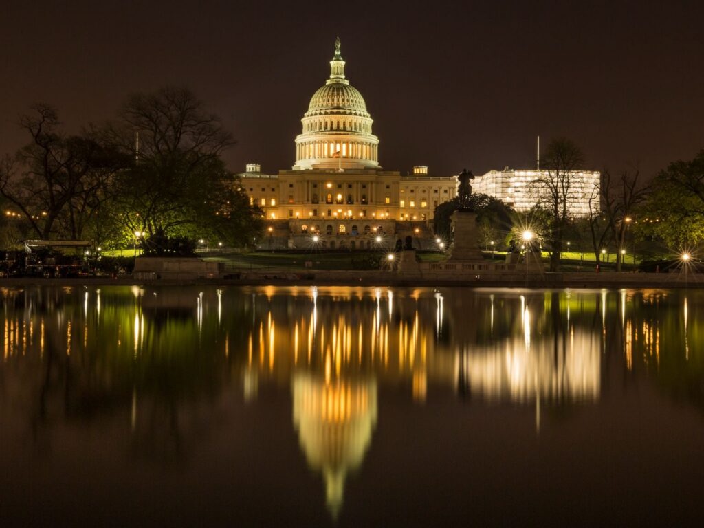 The US Capitol Building illuminated at night with a reflection in the water, Washington DC.