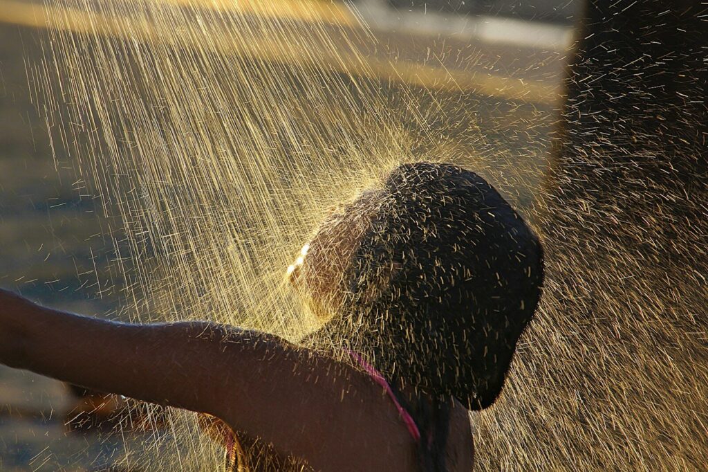 A child plays under a spray of water