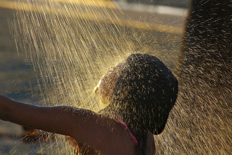 A child plays under a spray of water