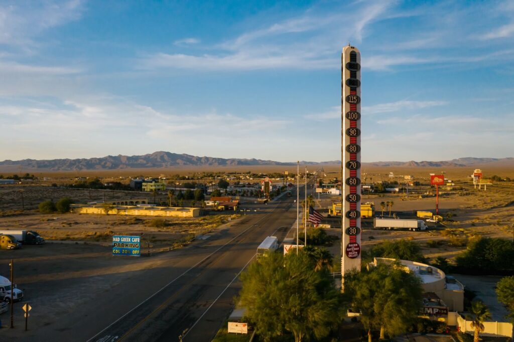 Aerial view of the World's Tallest Thermometer in Baker, California, along a desert highway.