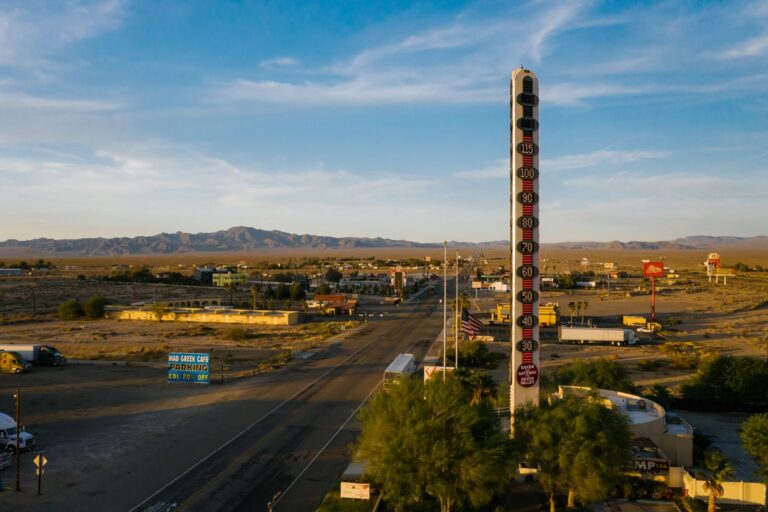 Aerial view of the World's Tallest Thermometer in Baker, California, along a desert highway.