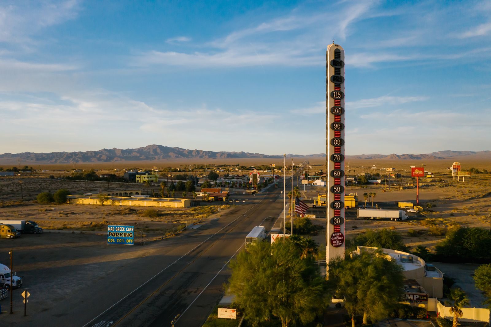 Aerial view of the World's Tallest Thermometer in Baker, California, along a desert highway.