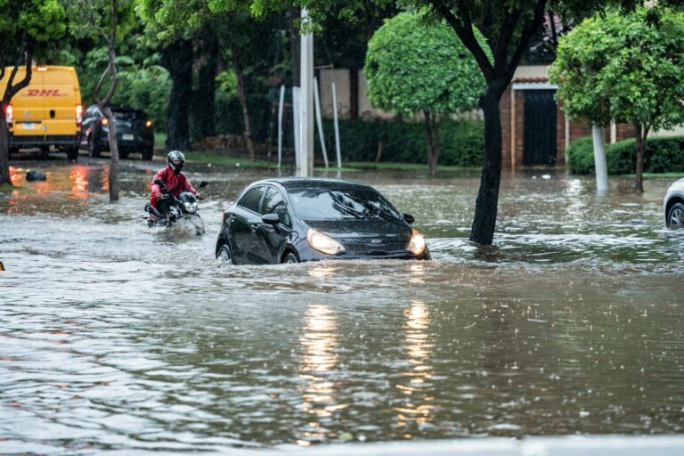 Cars driving through a flooded street during a storm