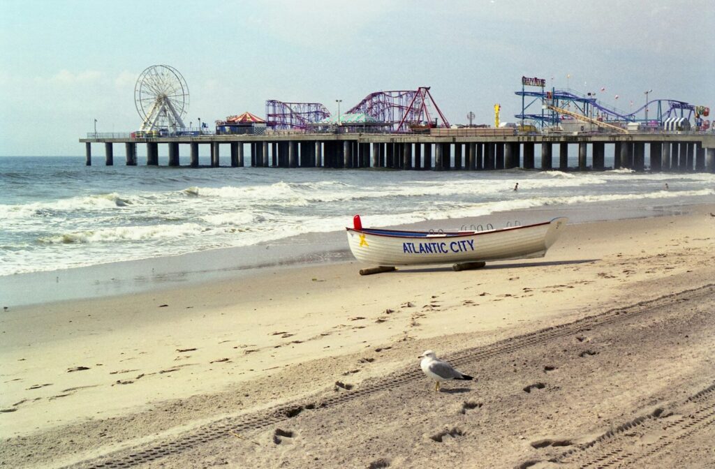A white lifeguard boat on the sand before the Atlantic City pier