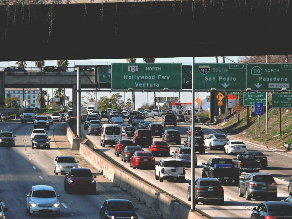 a highway filled with lots of traffic under a bridge