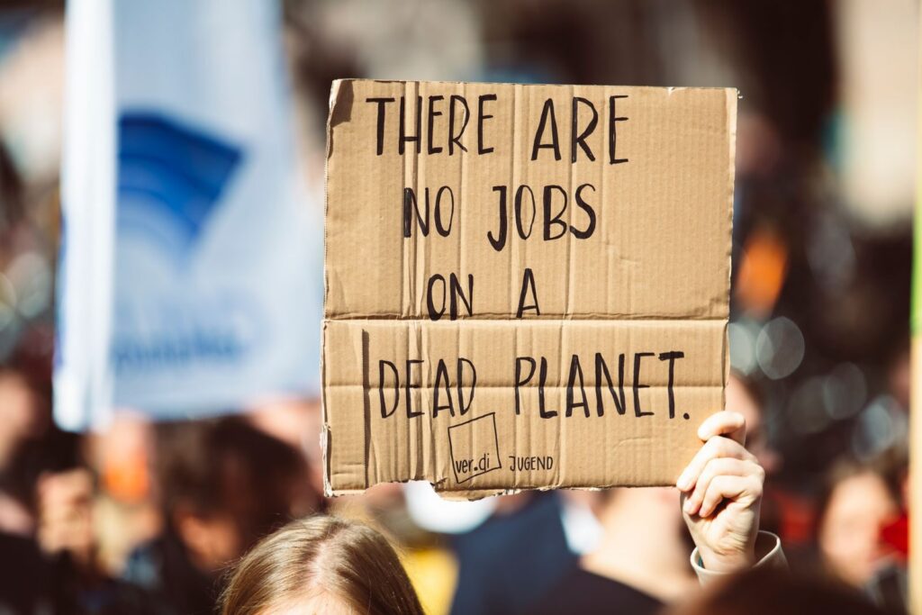 Cardboard sign at climate protest reads 'There are no jobs on a dead planet.'